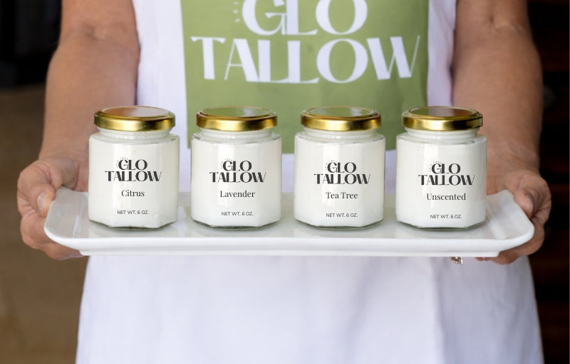 Four Jars of Glo Tallow display on a rectangle white platter. Women holding platter