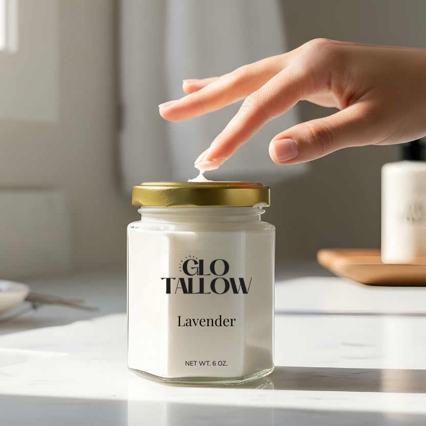 Hand opening a jar of 'Glo Tallow' lavender tallow on a table.