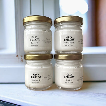 Four jars of Glo Tallow products on a windowsill.