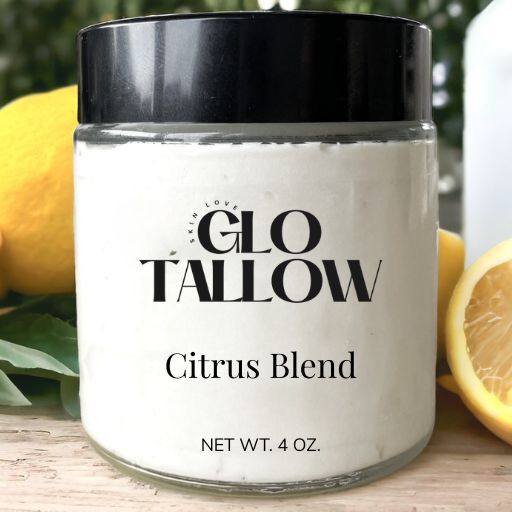Jar of GLO TALLOW Citrus Blend on a wooden surface with lemons in the background